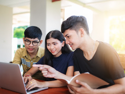 Three college students looking at computer